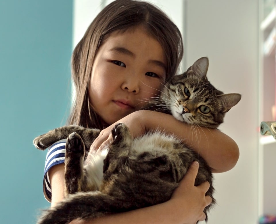 Child holding cat